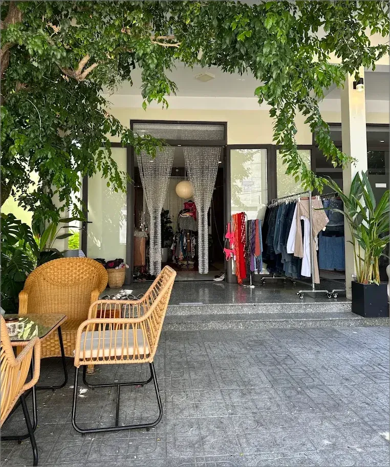 Rattan seating beneath the trees outside Yen May Vintage in Da Nang