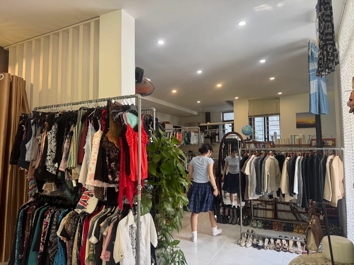 A customer browsing the curated clothing rails inside Yen May Vintage