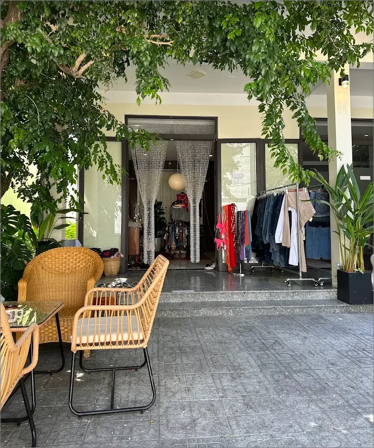 Rattan seating beneath the trees outside Yen May Vintage in Da Nang